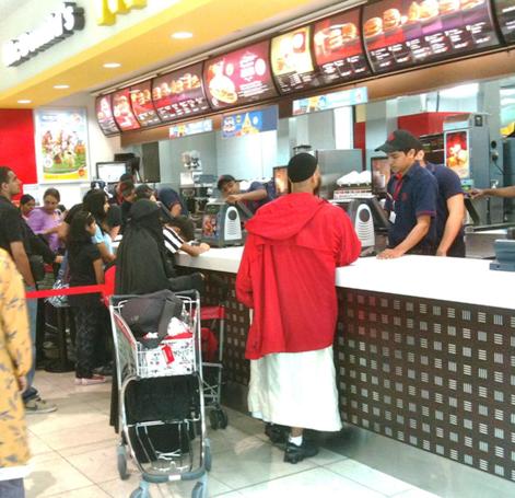 A women in a full burka at McDonalds at the Dubai Airport. Here, they are not hamburgers, they are beefburgers. Also, in Lahore, McDonalds delivers!