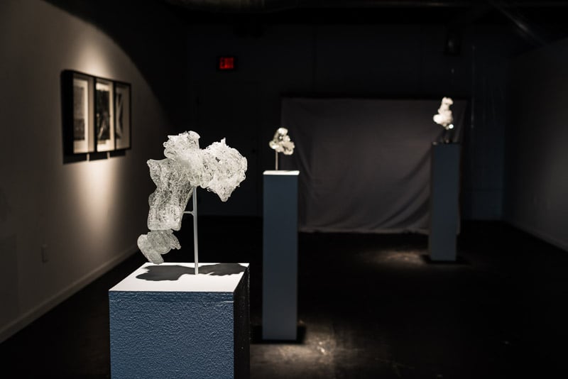 Installation view of Mesophase.  Glass into Water 2 (foreground); Reflect on the Broken 2 (triptych, left); Glass into Water 1 (center); Glass into water - Plunge 1 (right). Photo by Alisa Levy