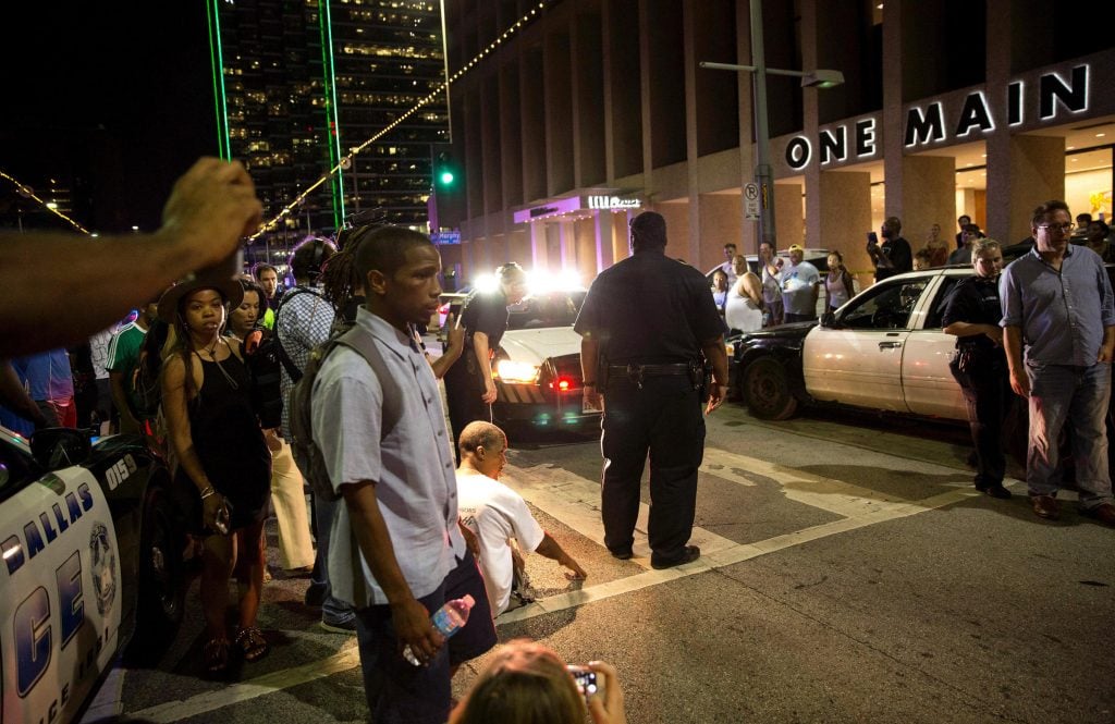 Police attempt to calm the crowd as someone is arrested near the scene of the sniper shooting in Dallas. Photo:LAURA BUCKMAN / AFP/GETTY IMAGES