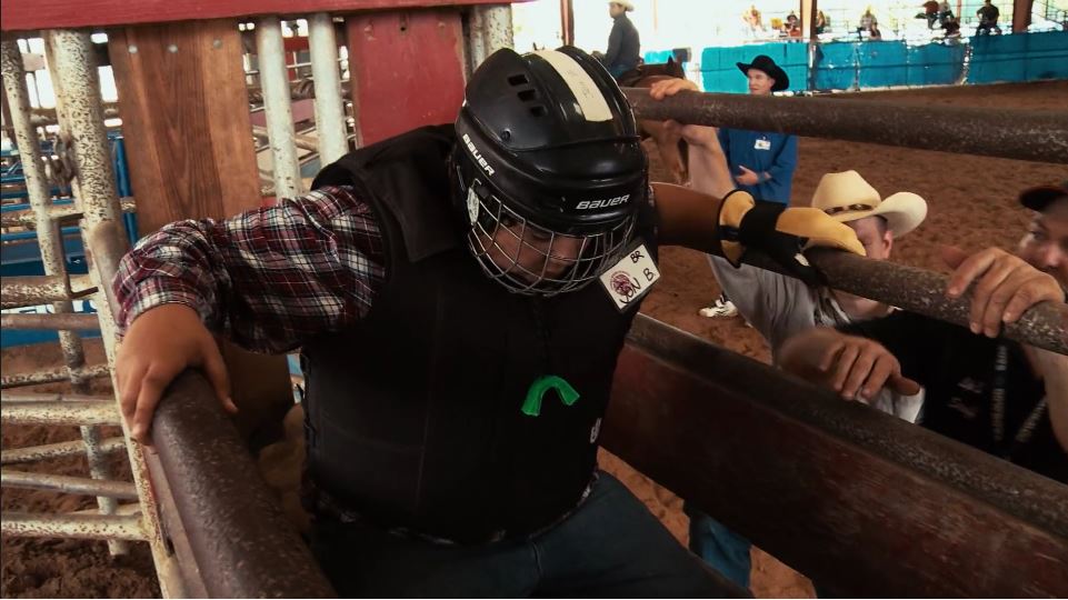 Jonathan prepares to ride a live bull at rodeo school.
