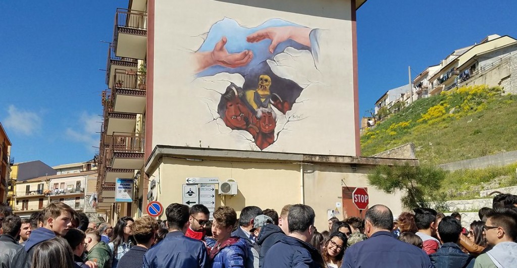 The official unveiling of Maria Haag’s mural celebrating the town’s Easter festival, ‘The Dance of the Devils,’ which involves Death (in yellow) and his hellish minions trying to prevent Jesus from reuniting with the Virgin Mary (the two hands).