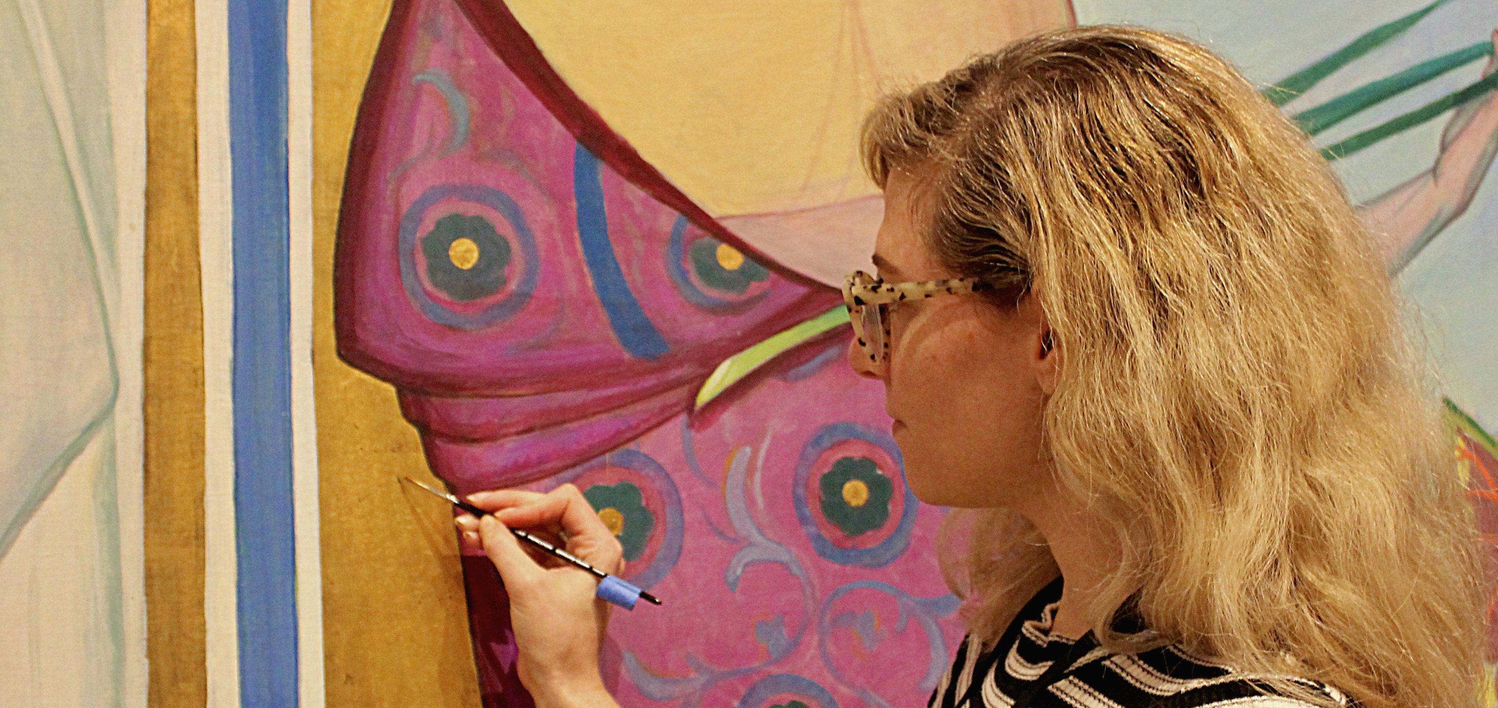 Laura Hartman retouching gold leaf on a Steichen painting
