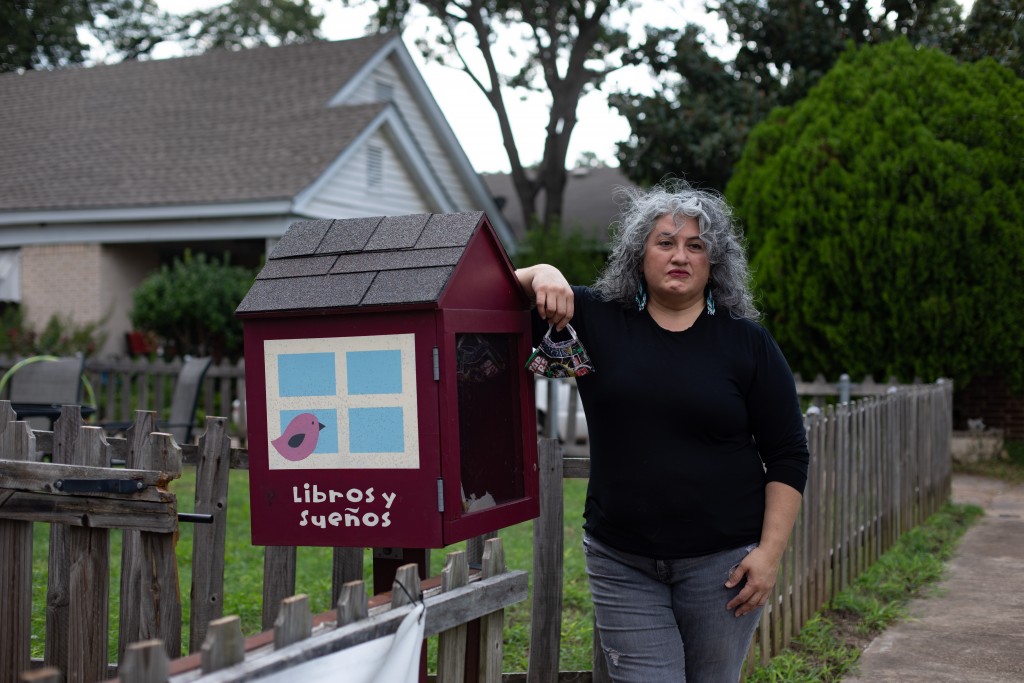 Ofelia Faz-Garza poses for a portrait next to a community library she built outside her home in Oak Cliff.