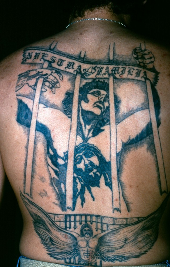 Photo of a former prison inmate's tattoo of Jesus behind a prison cell.