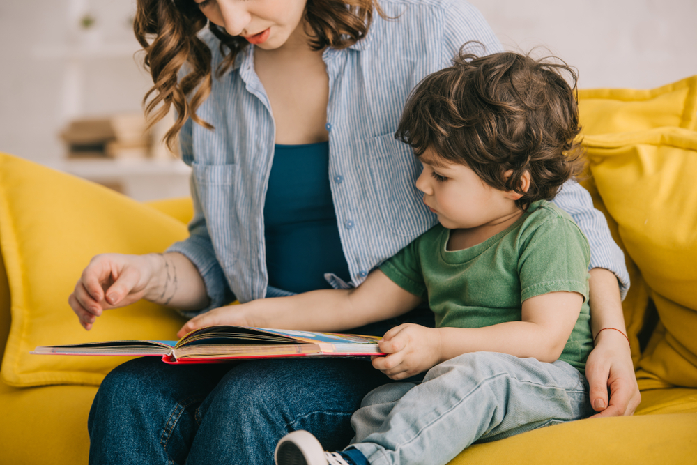 woman reading book to little boy
